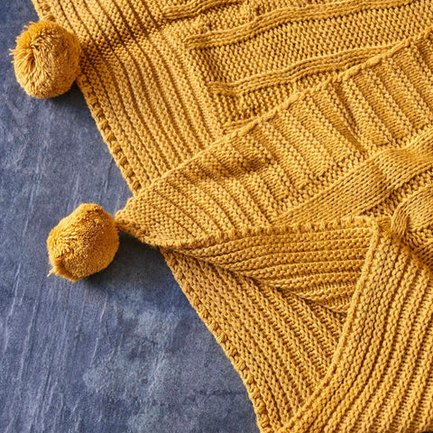 Karaca Home gestrickte Bommel Decke dunkelgelb